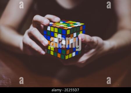 BANGA, PH– MAY 30, 2019: Rubik's Cube was invented in 1974 by Hungarian sculptor and professor of architecture Erno Rubik. Young lady hands on cube. Stock Photo