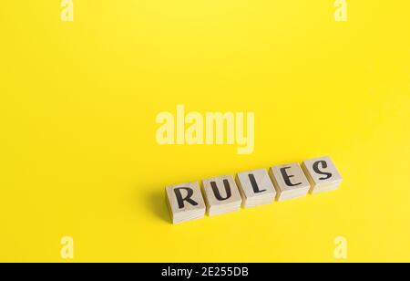 Blocks with the word Rules on yellow background. Laws and community ethics norms. Terms of the contract and the obligations of the parties. Control an Stock Photo