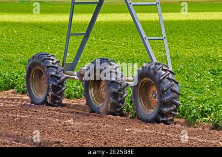 Closeup shot of wheels of western circular sprinkler on a greenfield Stock Photo