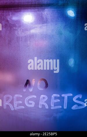 words no regrets hand written on purple-blue night foggy window glass Stock Photo