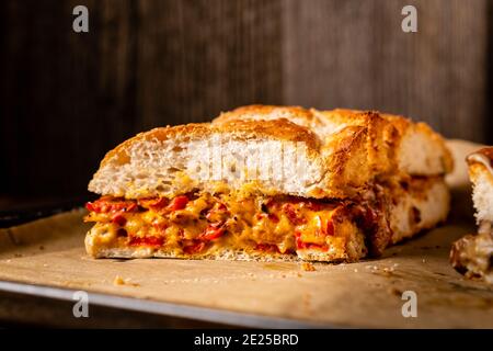 Grilled cheese sandwich with vegan cheese and red bell pepper in front of a rustic wooden background with copy space. Popular American fast food dish Stock Photo