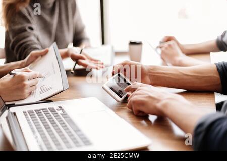 employee is using his smartphone to check the financial data. Stock Photo