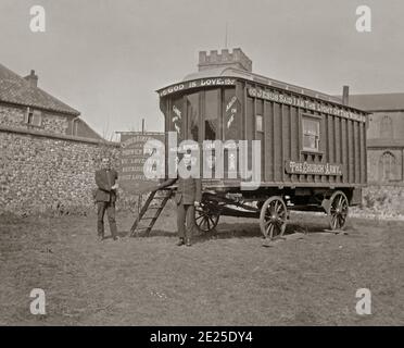 A Victorian photograph of a horse-drawn Church Army caravan (Norwich No 1) with two uniformed ‘officers’ in Norfolk c.1900. The caravan is covered in Christian sayings, as is a banner the men hold. The Church Army was an organisation of lay evangelists within the Church of England, founded on the model of the Salvation Army in the slums of London in 1882 by Wilson Carlile. The evangelists on these vans would take services in schools and open-air meetings. Initially these vans were pulled by horses but later became motorised. Stock Photo