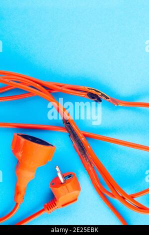 burnt electrical wire on blue background. Copy space Stock Photo