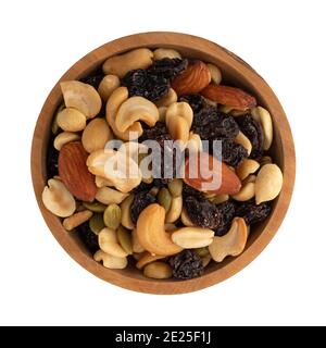 An assortment of nuts and dried fruit in a wood bowl isolated on a white background. Stock Photo