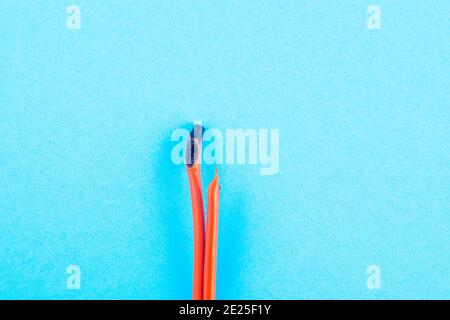burnt electrical wire on blue background. Copy space Stock Photo