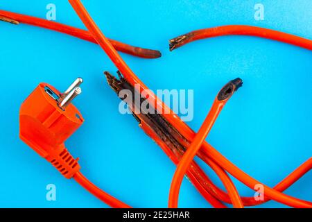 burnt electrical wire on blue background. Stock Photo