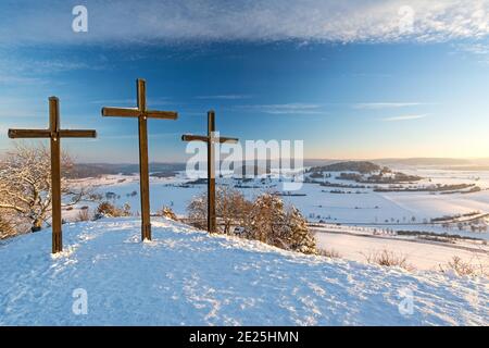 Three summit crosses on a mountain peak in a beautiful winter landscape in the Swabian Alps at sunset Stock Photo