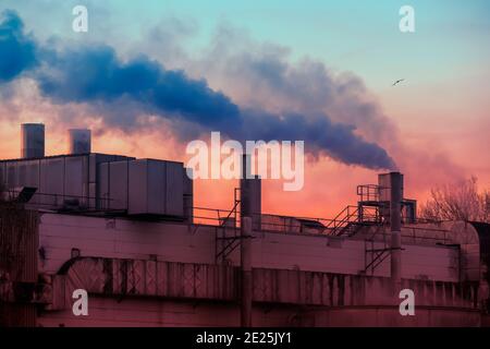 Dark smoke comming from the chimneys of an old factory. Stock Photo