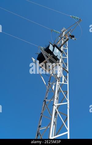 Power pole for electricity transmission and distribution in front of blue sky Stock Photo