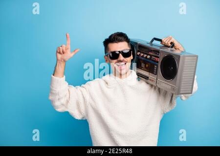 Photo portrait of cool dude with stubble pointing finger up holding boombox on shoulder isolated on pastel blue colored background Stock Photo