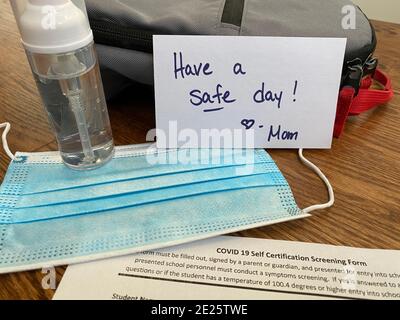 The new normal for school supplies in the time of COVID. Daily packing lists for in-person learning now include sanitizer, masks, and screening forms. Stock Photo