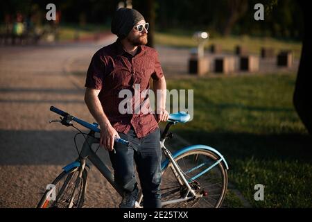 A handsome male with bicycle and backpack Stock Photo