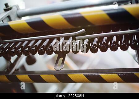 black preforms for blowing plastic PET bottles move on a conveyor belt Stock Photo