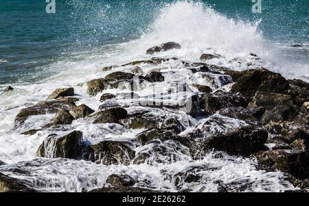 Closeup of waves crashing on rocks Stock Photo