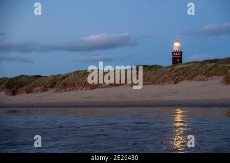 Lighthouse standing on the Dutch coast with a dramatic. and colorful dusk or dawn sky behind it. High quality photo Stock Photo
