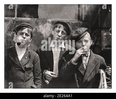 smoking cigarettes at 14 1900's archive young streetwise boys 10-14 years smoking cigarettes and a  pipe, Franklin, St. Louis. USA 1907 Stock Photo