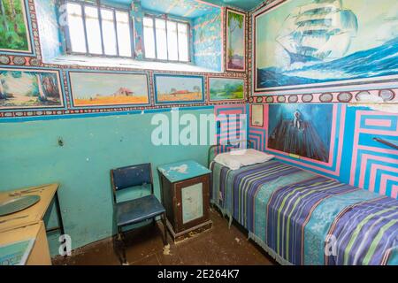 Fremantle, Western Australia - Jan 5, 2018: single cell with bed and painting of Fremantle Prison an old convicts jail built in 1855. Memorial museum Stock Photo