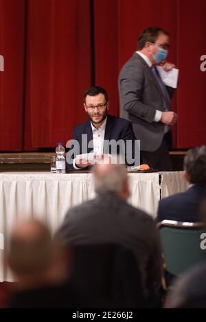 Bernburg, Germany. 12th Jan, 2021. Alexander Goebel (CDU), sits at the podium in the hall of the Kurhaus. Behind goes the incumbent District Administrator Markus Bauer (SPD) to the podium. In the evening, the candidates for the upcoming district administrator election were presented to the public there. The election of the district administrator scheduled for January 24, 2020 can take place. Credit: Klaus-Dietmar Gabbert/dpa-Zentralbild/dpa/Alamy Live News Stock Photo