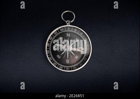 Compass isolated on dark background. Close-up. Stock Photo