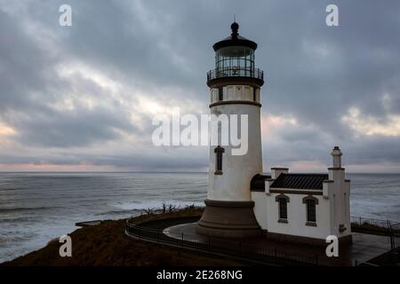 WA19108-00...WASHINGTON - Cloudy morning sunrise at North Cape Lighthouse in Cape Disappointment State Park. Stock Photo