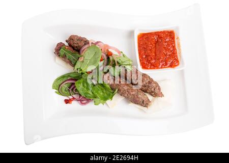 Beef kebab with spicy tomato sauce on skewers. Isolated in a white background. Close-up. Stock Photo