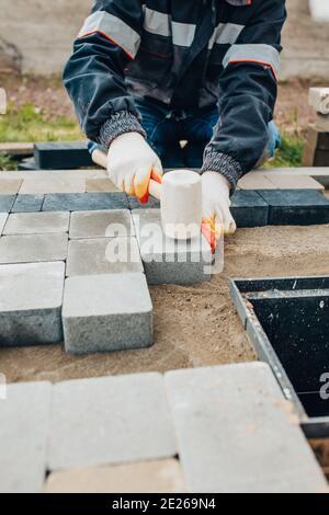 Professional laying of road stone and paving slabs for walking and parking - sidewalk paving Stock Photo