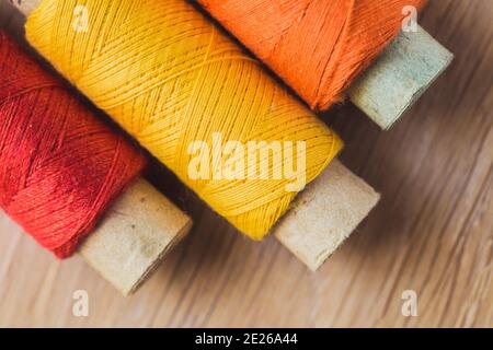 Three spools of multicolored sewing thread - needlework and hobby - embroidery on fabric Stock Photo