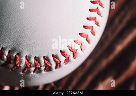 Seam with red thread on the white leather of a baseball - macro close-up Stock Photo