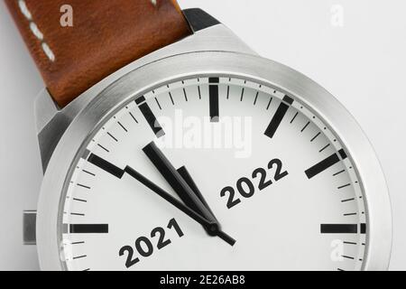 Macro photo of a modern metal watch with the text Two thousand and twenty one and two thousand and twenty two on the dial Stock Photo