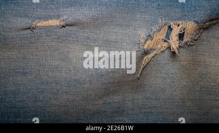 Ripped blue jeans, denim texture, background from denim fabric. Stock Photo
