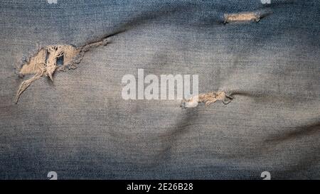 Ripped jeans texture, blue jeans top view. Denim background. Stock Photo