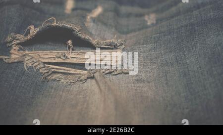 The texture of ripped jeans with beautiful toning, light jeans background. Textile. Stock Photo
