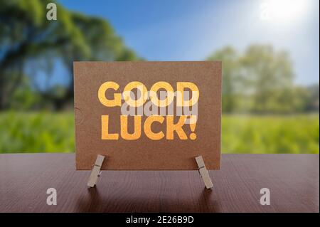 Good luck text on card on the table with sunny green park background. Stock Photo