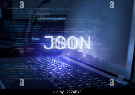 JSON inscription against laptop and code background. Technology concept. Stock Photo