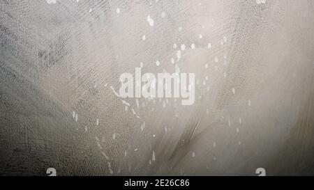 The texture of the painted wall in its modern form. Abstract background, splashes of white paints on the wall. Scratched background. Stock Photo