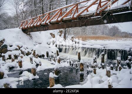 footbridge over a pond with a small waterfall winter day Stock Photo