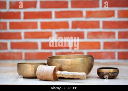 Tibetan singing bowls with sticks on the wall background - music instruments for meditation, relaxation after yoga practice and healing massage. High quality photo Stock Photo