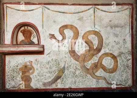 Pompeii ruins. Fresco with snakes in garden. UNESCO World Heritage Site in Campania, Italy. Europe heritage and culture concept. Stock Photo