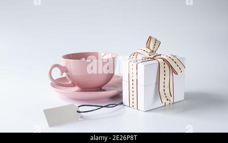 Father's day holiday greeting card. Mug tea coffee and present gift box with bow on white pastel background. Copy space, mock up, Birthday day, mother Stock Photo