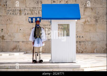 Soldier of the Greek presidential guard (Evzone) with facemask in front of the tomb of the unknown soldier in Athens, Greece Stock Photo