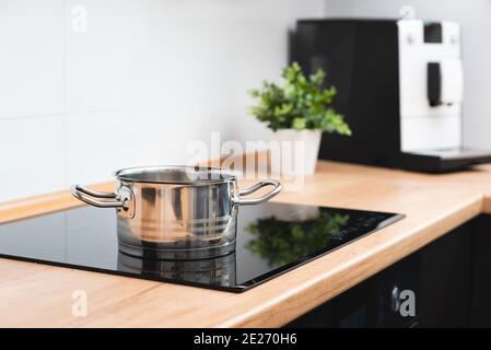 Pot in the kitchen on the induction hob. Induction electrical stove Stock Photo