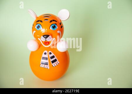 Bright plastic toy-tumbler as tiger on green background Stock Photo
