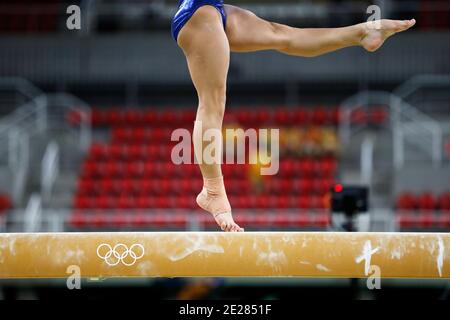 Balance beam artistic gymnastics competition performance. Close up detail of woman athlete feet on air, jump training session exercise indoors Stock Photo
