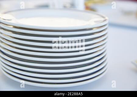 A stack of white plates on a light background. Life style. Stock Photo