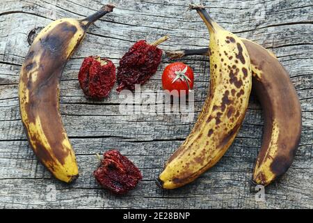 Old brown bananas and dried peppers and tomatoes. Old fruit and vegetables Stock Photo