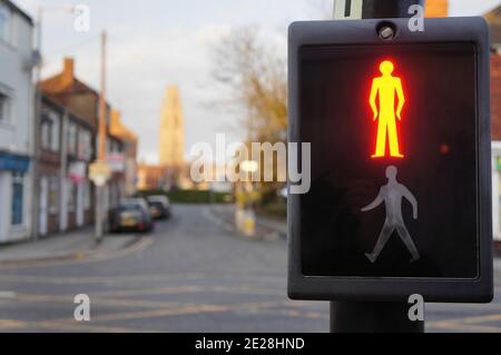 Close up of the wait sign of a pedestrian crossing with soft focus background of a street and the stump tower Stock Photo