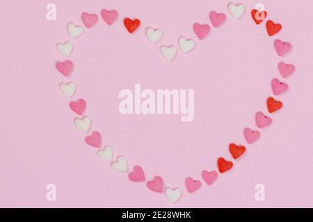 Blank heart made of small candy hearts on pink background. Valentines day candy hearts. Copy space. Stock Photo