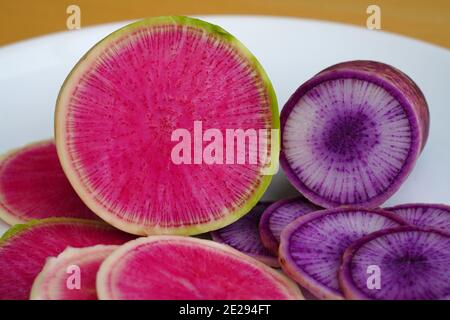 Slices of green and pink watermelon (red meat) radish and purple Blue Meat radish Stock Photo