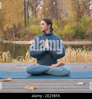 Young pretty woman doing yoga poses in the park autumn. High quality photo Stock Photo